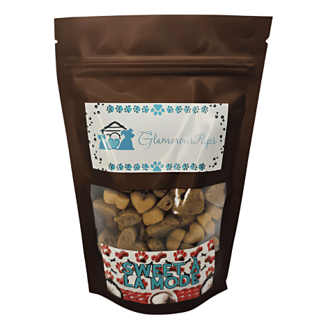 Packaging of Sweet À La Mode Dog Treats by Glamorous Pups, 8oz bag. The sleek, resealable bag features a transparent window showcasing heart-shaped and bone-shaped treats, topped with a stylish label adorned with blue paw prints and the Glamorous Pups logo. The lower portion highlights the 'Sweet À La Mode' label in a festive red and white design, ideal for pet owners looking for gourmet, all-natural treats crafted in the USA.