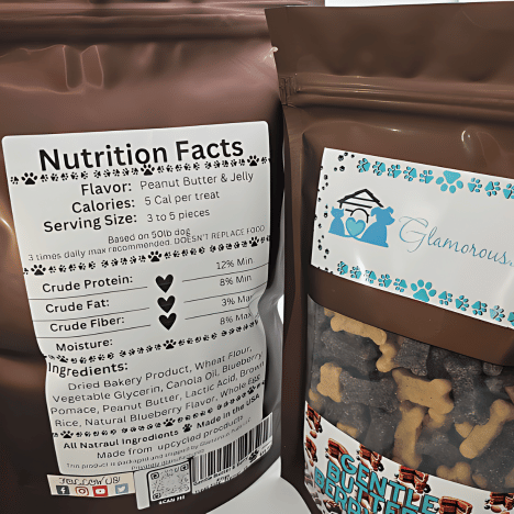 Close-up image of the nutrition facts label and packaging for Gentle Berry Bites, a dog treat product by Glamorous Pups. The label displays information such as flavor (Peanut Butter & Jelly), calories, and ingredient list, with a clear window showing the bone-shaped treats inside the bag. The Glamorous Pups logo and attractive packaging design emphasize the brand's commitment to quality and natural ingredients for pet nutrition.