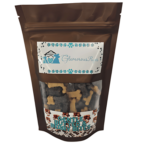 8oz resealable bag of Gentle Berry Bites by Glamorous Pups, displaying a sleek brown design with a clear viewing window that reveals the bone-shaped dog treats inside. The label features the Glamorous Pups logo surrounded by blue paw prints and the product name 'Gentle Butter & Berry Bites' in attractive typography. This packaging highlights the treats' natural ingredients and nutritious benefits, appealing to pet owners looking for high-quality, healthy snacks for their dogs.