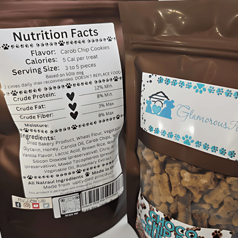 Close-up of the nutritional label on a Choco-Chip Pup Crunchers Dog Treats package by Glamorous Pups, detailing the low-calorie content and rich ingredients like carob chips, wheat flour, and honey. The label on the glamorous brown bag highlights these treats as an all-natural, delicious choice for pet owners.