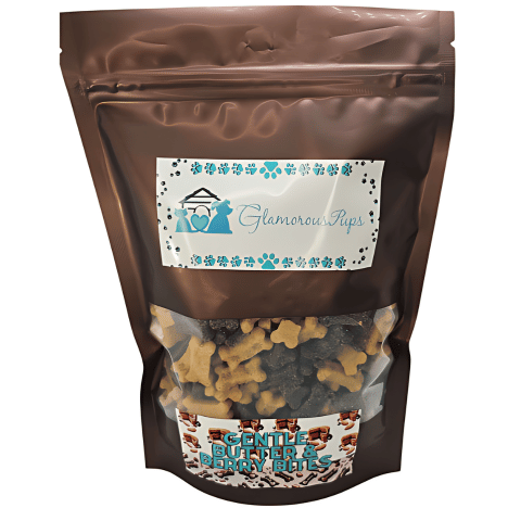 1lb resealable bag of Gentle Berry Bites by Glamorous Pups, featuring a glossy brown design with a transparent window that showcases the bone-shaped dog treats inside. The packaging includes the Glamorous Pups logo adorned with blue paw prints and clearly displays the product name 'Gentle Berry Bites.' This attractive bag emphasizes the treats' natural and nutritious ingredients, catering to pet owners seeking healthy, tasty, and responsibly made snacks for their dogs.