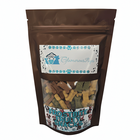 Showcasing the 1lb bag of Frostbite Fruity Snacks Dog Treats by Glamorous Pups, the packaging features a transparent window revealing multi-colored, bone-shaped treats, perfect for dogs. The design includes the iconic Glamorous Pups branding with a winter-themed graphic, highlighting the all-natural, made in the USA ingredients for a healthy treat option.