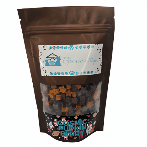 High-quality image of an 8-ounce bag of Cosmic Pupkin Berry Dog Treats by Glamorous Pups, featuring a clear window displaying uniquely shaped, vibrant treats, with a decorative label including blue floral motifs and the Glamorous Pups logo, highlighting premium and healthy dog treats.