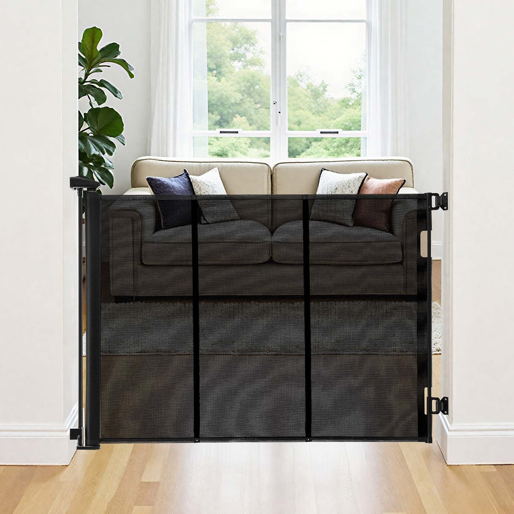 Black mesh pet gate in a living room with a couch and window in the background