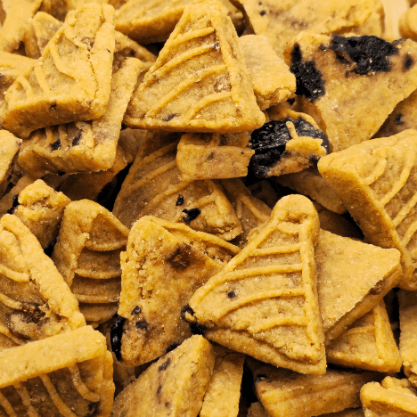 Close-up view of Blueberry Pupcake Party dog treats by Glamorous Pups, featuring a dense arrangement of pancake-shaped treats interspersed with generous chunks of real blueberries. The treats' detailed embossed patterns and rich, natural color showcase their premium quality and enticing flavor, making them an ideal choice for health-conscious pet owners looking for nutritious, USA-made dog snacks.