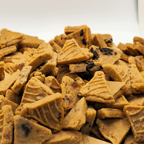 Heaping pile of Blueberry Pupcake Party treats by Glamorous Pups, closely showcasing the pancake-shaped dog treats enriched with real blueberry bits. The detailed texture of these all-natural treats highlights their quality and appeal, perfect for pet owners seeking delicious and healthy snack options for their dogs. Manufactured in the USA, these treats promote a nutritious diet with a burst of blueberry flavor.