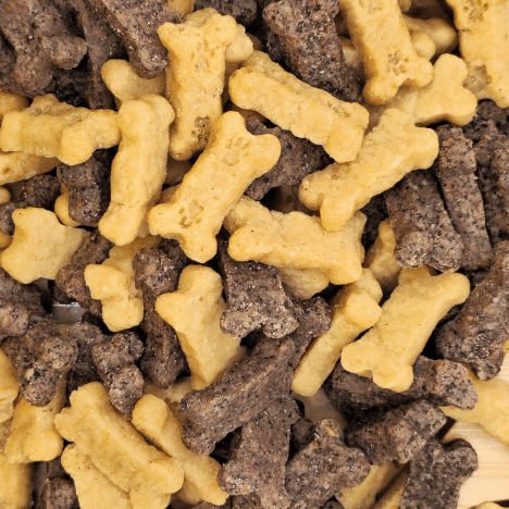 Close-up image of Gentle Berry Bites by Glamorous Pups piled on a wooden surface, featuring bone-shaped dog treats in light beige and dark brown colors. These high-quality treats are crafted from natural, berry-infused ingredients, perfect for healthy snacking and effective dog training. The image emphasizes the appeal and nutritional value of these treats for health-conscious pet owners.