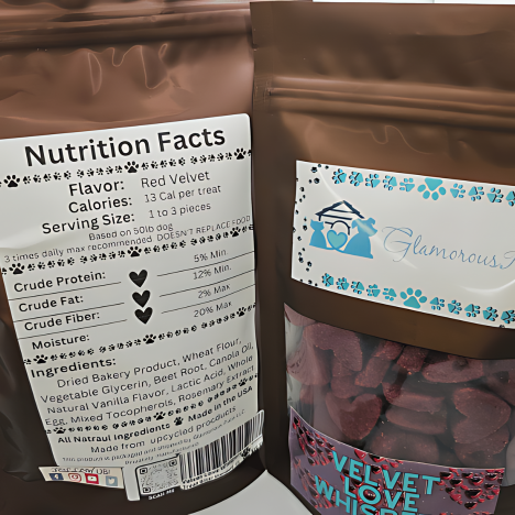 Close-up view of Velvet Love Whispers Dog Treats by Glamorous Pups, featuring a detailed nutrition facts label. The brown resealable bag showcases rich, heart-shaped red velvet treats, emphasizing their all-natural ingredients and gourmet flavor, perfect for pampering your pet.