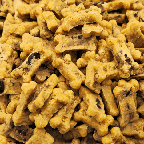 Close-up view of Choco-Chip Pup Crunchers Dog Treats by Glamorous Pups. These crunchy, bone-shaped treats are speckled with carob chips, offering a delicious and healthy snack option for dogs, perfect for rewarding good behavior.