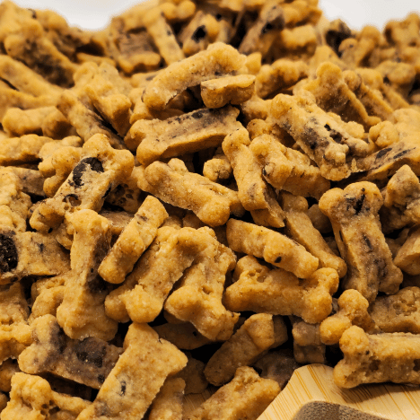 Zoomed-in texture of Choco-Chip Pup Crunchers Dog Treats by Glamorous Pups, showcasing the appetizing blend of carob chips embedded in these crunchy, bone-shaped treats, tailored for dog enjoyment and health.