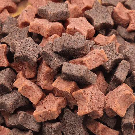 Zoomed-in view of Galactic Berry Gems Dog Treats by Glamorous Pups, highlighting the detailed texture and vibrant mixed berry colors. These artisanal dog treats, shaped like stars and bones, are crafted with natural ingredients like blueberries and cranberries, offering a healthy, tasty snack option for dogs.