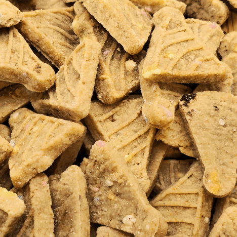 Close-up view of Banana Bash Caps Dog Treats by Glamorous Pups, featuring their distinctive triangular shape and enticing banana-flavored bits. These premium, all-natural dog treats are carefully crafted to provide a delicious and healthy snack for dogs, promoting Glamorous Pups' commitment to high-quality pet products.