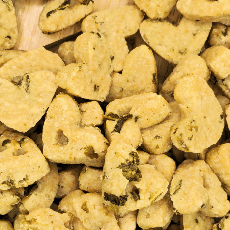 Close-up image of Leafy Garden MozzaMix Dog Treats by Glamorous Pups, displayed on a wooden paw-shaped serving board. Each treat is carefully crafted with natural ingredients like spinach, kale, and mozzarella, highlighting the brand's dedication to high-quality, nutritious dog snacks. Ideal for SEO enhancement focused on premium, health-conscious dog treats from Glamorous Pups.