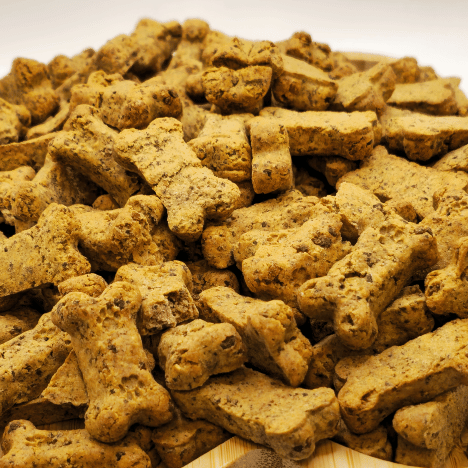 An inviting pile of Pupkin Patch Snacks Dog Treats by Glamorous Pups displayed on a wooden platter, featuring pumpkin-spiced, natural, nutritious bone-shaped treats perfect for canine health and training.