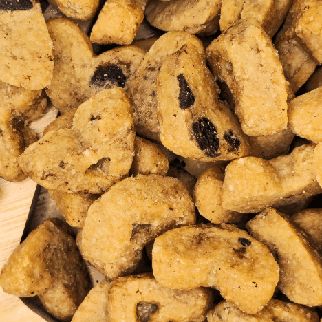 Zoomed-in view of Peanut Butter Pup Dog Treats by Glamorous Pups, showcasing delicious heart-shaped and traditional biscuit shapes with rich peanut chunks, ideal for pet owners seeking artisanal, USA-made dog snacks from Glamorous Pups.